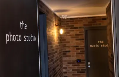 a brick wall with the photo studio studio sign next to a door at co.sleep in Rome