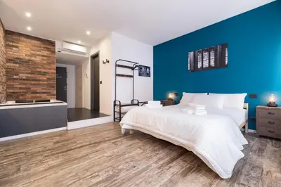 a bedroom with a large bed and a blue wall at co.sleep in Rome