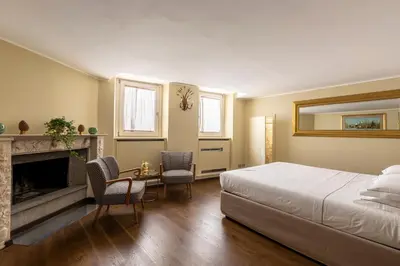 a bedroom with a bed and a fireplace at ROMAC Fontanella Borghese Palace in Rome