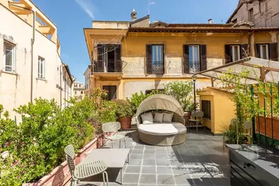 a patio with a couch and chairs on a balcony at ROMAC Fontanella Borghese Palace in Rome