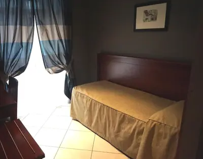 a bedroom with a bed and a window at Hotel Taormina in Rome
