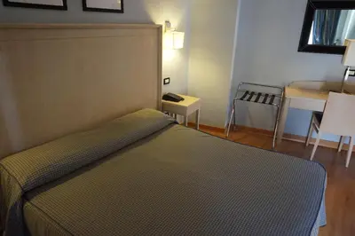 a bedroom with a bed and a table and a tableablish at Hotel Taormina in Rome