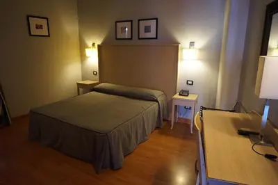 a hotel room with a bed and two tables at Hotel Taormina in Rome