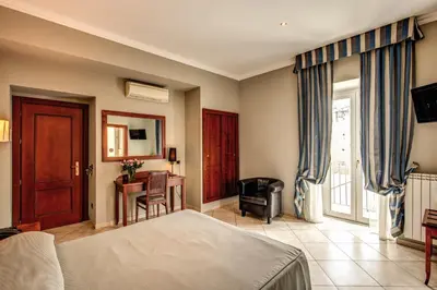 a bedroom with a bed and a desk and a chair at Hotel Taormina in Rome
