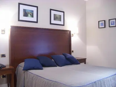 a bedroom with a bed with blue pillows on it at Hotel Taormina in Rome