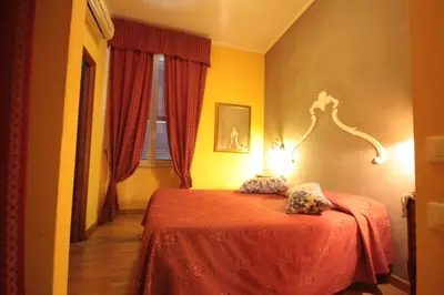 a bedroom with a bed with a red bedspread at Hotel Termini in Rome