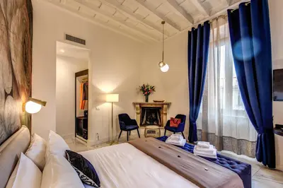 a bedroom with a large bed and a fireplace at Little Queen Pantheon in Rome