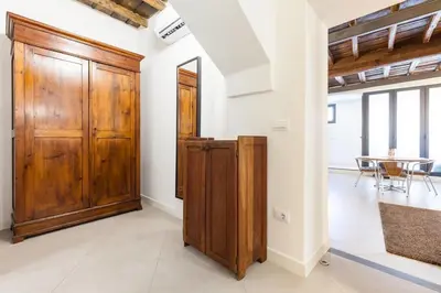 a room with a wooden door and a table at Maison Romana Loft in Rome