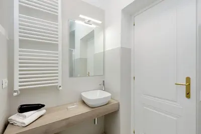 a white bathroom with a sink and a mirror at Modern Apartment Quirina 300 mt from Vatican in Rome