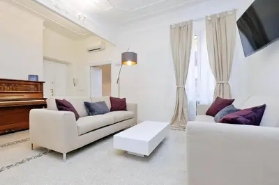 a living room with white furniture and a piano at Modern Apartment Quirina 300 mt from Vatican in Rome