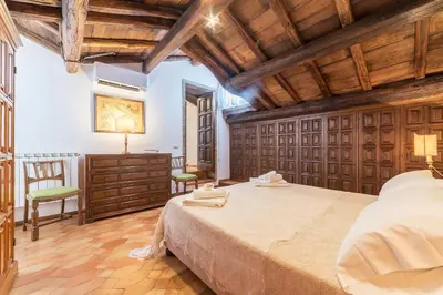 a bedroom with a large bed in a room with wooden ceilings at Trevi's Roof Terraces in Rome