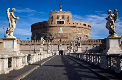 a bridge in front of a building with statues at NAVONA & CASTEL SANT'ANGELO WHOLE HOLIDAY APARTMENT da PAMINO & PRISCILLA in Rome