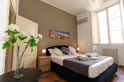 a bedroom with a bed and a vase of flowers on a table at Elegant Apartment in the Center of Rome! in Rome
