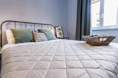a bedroom with a large bed with a wicker basket on it at MARCONI 94 - APARTMENT&PRIVATE ROOMS in Rome