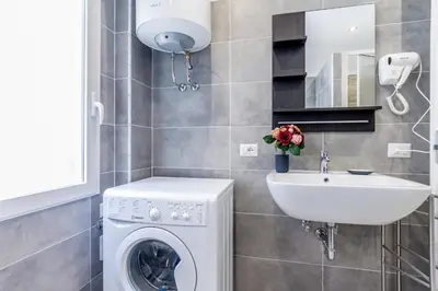 a bathroom with a washing machine and a sink at MARCONI 94 - APARTMENT&PRIVATE ROOMS in Rome