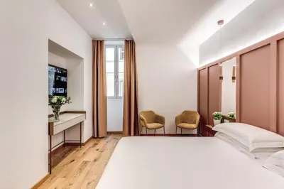 a bedroom with a bed and a desk and chairs at Relais Trevi 95 Boutique Hotel in Rome