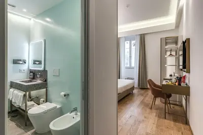 a bathroom with a sink and a toilet and a bed at Relais Trevi 95 Boutique Hotel in Rome