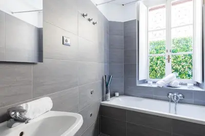 a bathroom with a tub and a sink and a window at A World Aparts - 32 Calabria in Rome