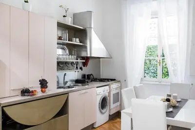a white kitchen with a sink and a dishwasher at A World Aparts - 32 Calabria in Rome