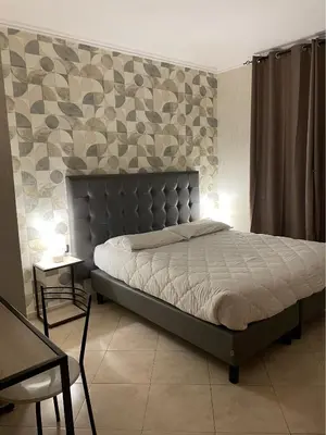 a bedroom with a large bed with a headboard at San Paolo Guest House in Rome