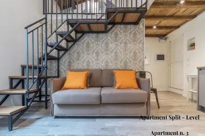 a living room with a couch and a spiral staircase at CS Exclusive Campo de Fiori Palace in Rome