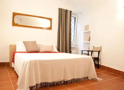 a bedroom with a bed and a mirror on the wall at TRASTEVERE - STUDIO APT. x 2 in Rome