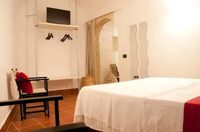 a bedroom with a bed and a chair and a tv at TRASTEVERE - STUDIO APT. x 2 in Rome