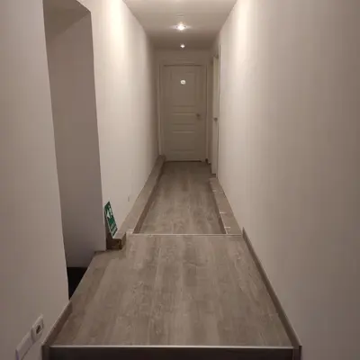 a hallway with a wooden floor and a white door at Elle Cavour Guest House in Rome