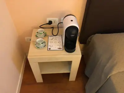a bedside table with a lamp and a clock on it at Elle Cavour Guest House in Rome