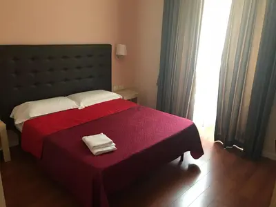 a bedroom with a large bed with a red blanket at Elle Cavour Guest House in Rome