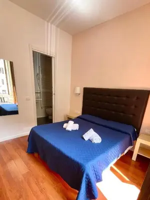 a bedroom with a blue bed with two towels on it at Elle Cavour Guest House in Rome
