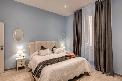 a bedroom with a bed with blue walls and a window at Vatican Royal Apartment in Rome