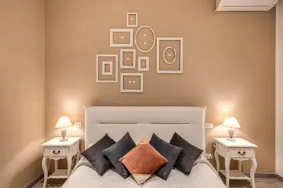 a bedroom with a white bed with two night stands at Vatican Royal Apartment in Rome
