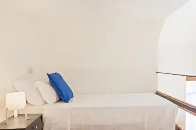 a bedroom with a bed with blue and white pillows at BDC - Colosseum Superior Apartment in Rome