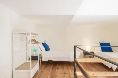 a white room with a bed and a staircase at BDC - Colosseum Superior Apartment in Rome