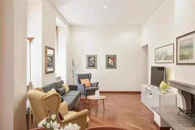 a living room with a couch and chairs and a tv at BDC - Colosseum Superior Apartment in Rome