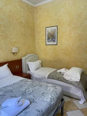 a room with two beds and a picture on the wall at Holiday Roma in Rome