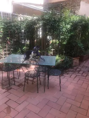 a glass table and chairs in a garden at Pantheon, Campo de fiori mini garden in Rome