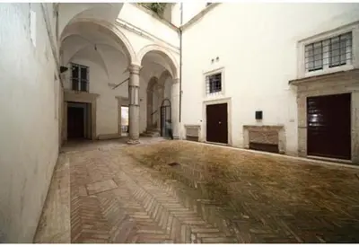 an empty courtyard of a white building with a stone floor at Pantheon, Campo de fiori mini garden in Rome