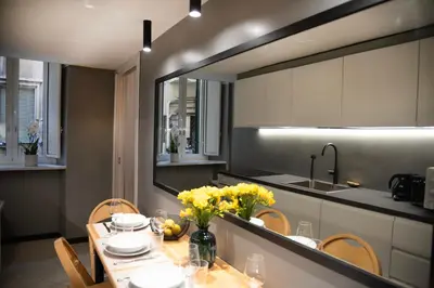 a kitchen with a table with yellow flowers on it at House Domusella in Rome
