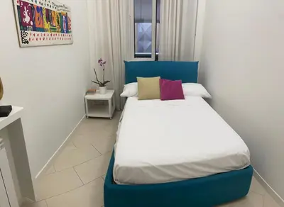 a bed with a blue headboard in a room at House Domusella in Rome