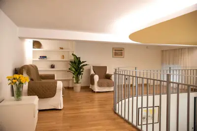 a living room with chairs and a spiral staircase at House Domusella in Rome