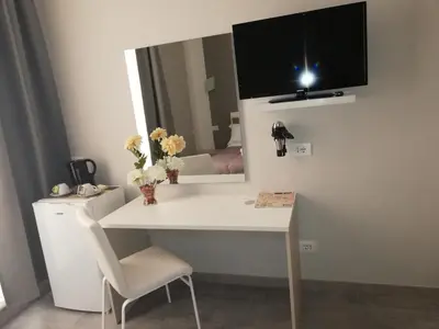 a room with a white desk and a mirror at Garden's Elide in Rome