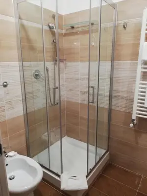 a bathroom with a shower and a toilet and a sink at Garden's Elide in Rome