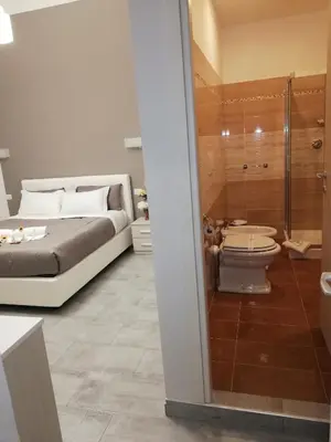 a bedroom with a bed and a toilet and a shower at Garden's Elide in Rome