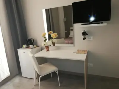 a white desk with a chair and a mirror at Garden's Elide in Rome