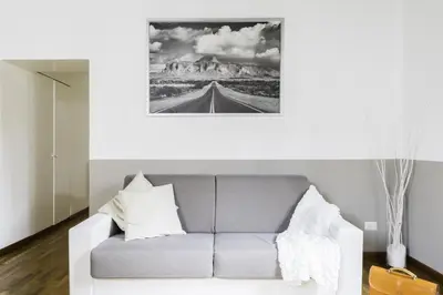 a living room with a couch and a picture of a mountain at A World Aparts - 105 Pellegrino in Rome
