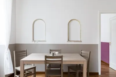 a dining room with a table and chairs and two mirrors at A World Aparts - 105 Pellegrino in Rome