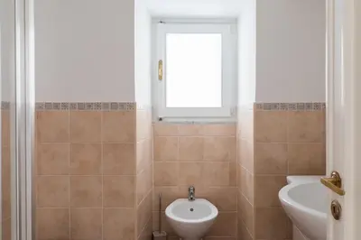 a bathroom with a sink and a toilet and a window at A World Aparts - 105 Pellegrino in Rome