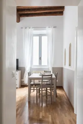 a dining room with a table and chairs and a window at A World Aparts - 105 Pellegrino in Rome